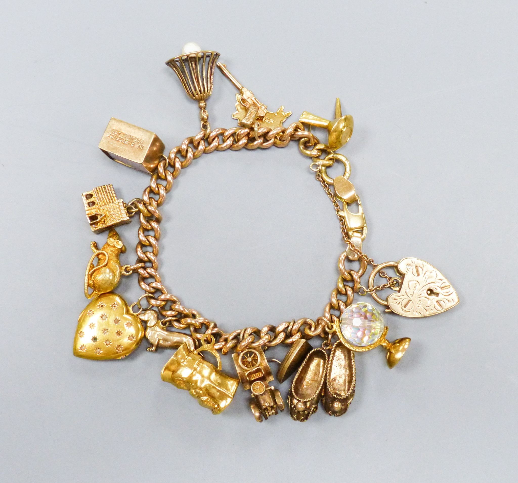 A 15ct rose gold chain charm bracelet, with 9ct and other charms to include animals, a motorcar etc. gross weight 69.0grams.